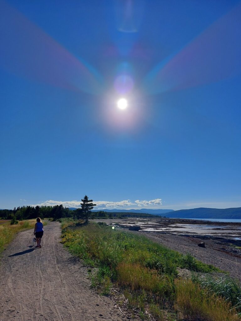 Nathalie et Shiro marchant sur un chemin le long du fleuve à La Malbaie