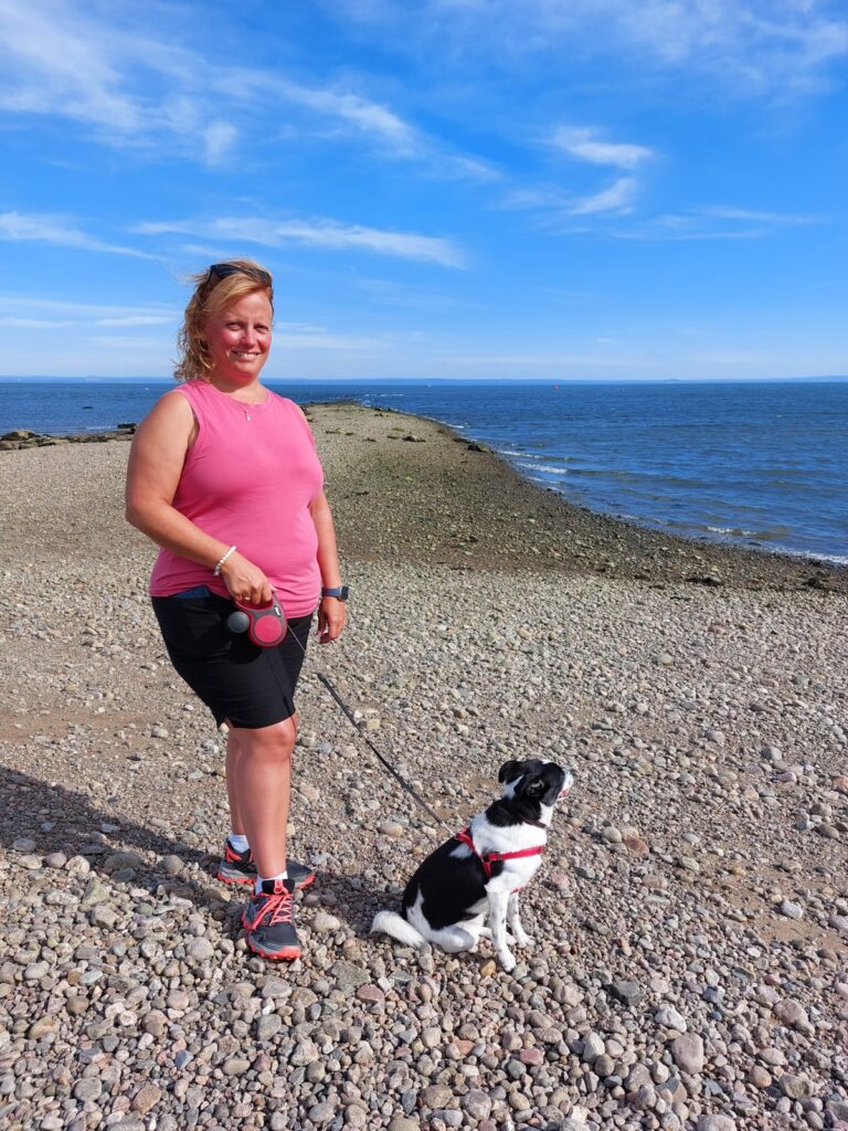 Nathalie et Shiro en laisse sur la plage de galets à La Malbaie