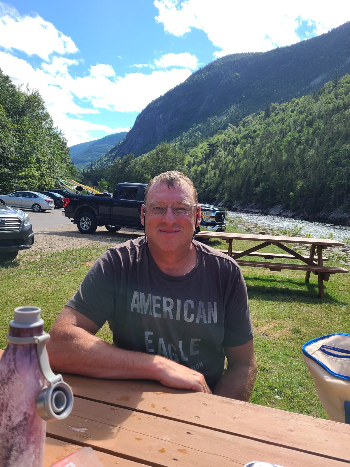 Christian à une table de pique-nique, avec le pickup et nos deux kayaks derrière